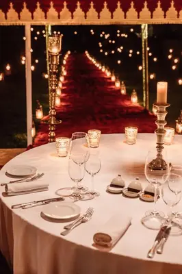 a table with glasses and silverware on a white table cloth at Amanjena Resort in Marrakech