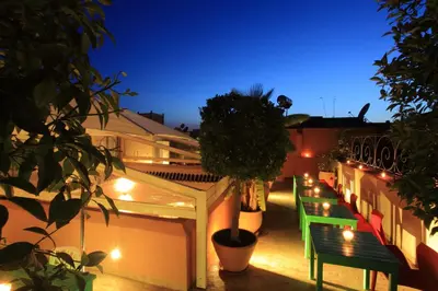 a row of benches on a balcony at night at Riad Infinity Sea in Marrakech