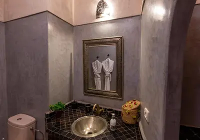 a bathroom with a sink and a mirror and a toilet at Les Sources berbères Riad & Spa in Marrakech