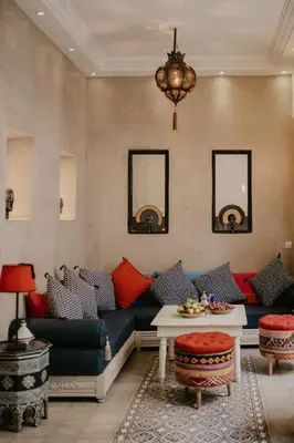 a living room with a blue couch and red pillows at Riad Alnadine in Marrakech