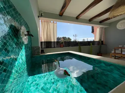 a swimming pool with a swan in the middle at Chimera Apartments & Suites in Marrakech