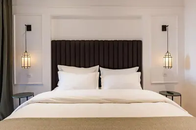 a bedroom with a large white bed with two lamps at Chimera Apartments & Suites in Marrakech