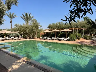 a large swimming pool with chairs and umbrellas at CASA ABRACADABRA in Marrakech