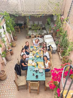 a group of people sitting around a long table at Riad Minami in Marrakech
