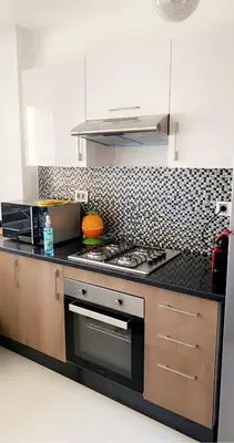 a kitchen with a stove and a counter top at Comme a la maison Prestigia Golf acces piscine in Marrakech