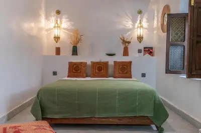 a bedroom with a bed with a green blanket at Riad Babouchta & Spa in Marrakech
