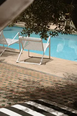two white chairs sitting next to a swimming pool at MORO Marrakech Boutique Hôtel in Marrakech