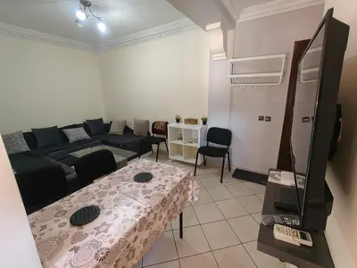 a living room with a table and a couch at Bright Air Conditioned Apartment Near City Center in Marrakech
