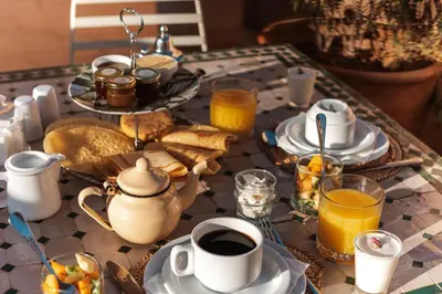 a table topped with plates and cups of coffee and toast at Riad Agathe & Spa in Marrakech