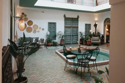a living room with a table and chairs at Riad Agathe & Spa in Marrakech