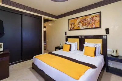 a bedroom with a large bed with a yellow blanket at Villa avec piscine - Petit déjeuner Gratuit - Marrakech City Center in Marrakech