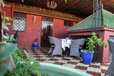a patio with wicker chairs and a table in front of a building at Riad Fattouma Kasba in Marrakech