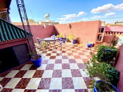 a patio with a table and a checkered floor at Riad Fattouma Kasba in Marrakech