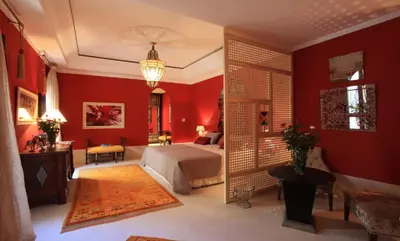 a bedroom with red walls and a bed in a room at Palais Khum in Marrakech