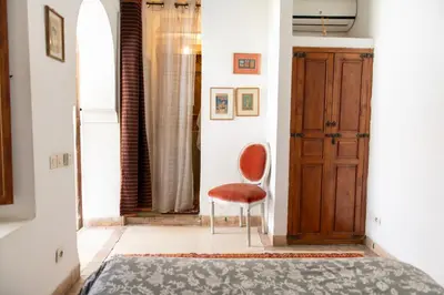 a bedroom with a chair and a door at Riad Ben Youssef in Marrakech