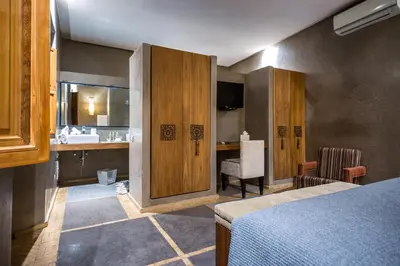 a room with a bed and a bathroom with a sink at Riad Houma in Marrakech