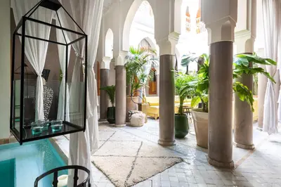 a room with a swimming pool and some potted plants at Riad Houma in Marrakech