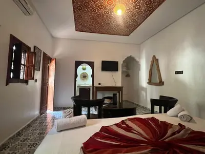 a bedroom with a bed and a desk in a room at Oloft in Marrakech