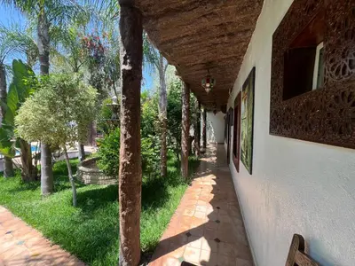 a walkway next to a white building with trees at Oloft in Marrakech