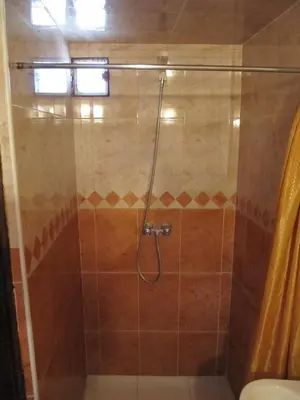 a shower with a glass door in a bathroom at Sindi Sud in Marrakech