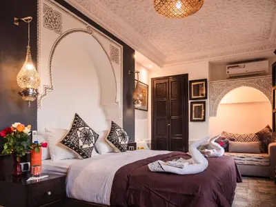 two swans are sitting on a bed in a room at Riad Zagouda in Marrakech