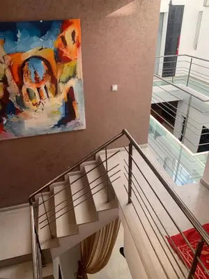 a painting hanging on a wall next to a staircase at RIAD LE PATIO ROMANTIQUE in Marrakech