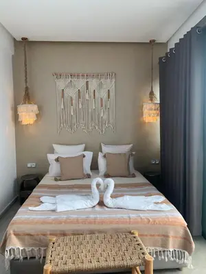 a bedroom with a bed with two swans on it at RIAD LE PATIO ROMANTIQUE in Marrakech