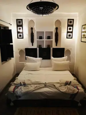 a large bed in a bedroom with a chandelier at Riad Dialna in Marrakech
