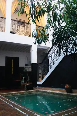 a house with a swimming pool in front of a building at Riad Dialna in Marrakech