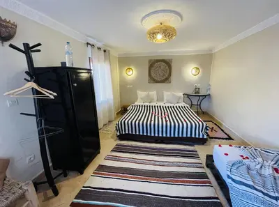a bedroom with two beds and a rug at Riad Dialna in Marrakech