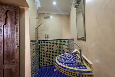 a bathroom with a blue and white mosaic sink at Riad Salman in Marrakech