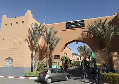 a car parked in front of a building with palm trees at Riads Dar ZAO - logements entiers in Marrakech