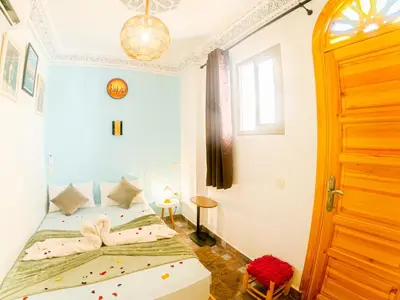 a bedroom with two beds and a door at Riad Dar Yassine in Marrakech
