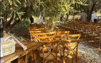 a row of chairs and a wooden table with chairs at Jnan Lotf Marrakech - Le Jardin de la Bienveillance in Marrakech