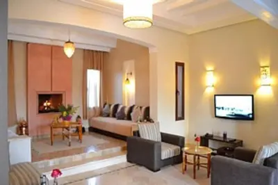 a living room with a couch and a tv at Villa Selma avec piscine chauffée in Marrakech