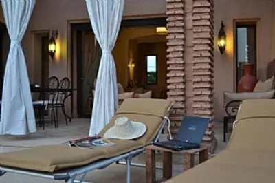 a room with a couch and a laptop on a table at Villa Selma avec piscine chauffée in Marrakech