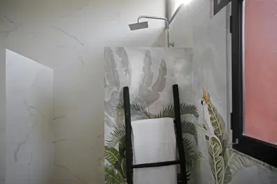 a bathroom with a towel rack with a painting on the wall at Villa LOULA in Marrakech