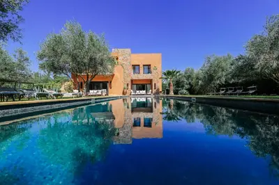 a large pool of water in front of a building at Villa ZITOUNA in Marrakech