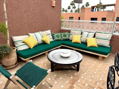 a patio with a green couch and a table and chairs at 