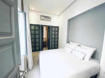 a bedroom with a white bed and a window at AZ RIAD in Marrakech