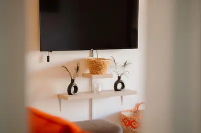 a room with two shelves with vases and a flat screen tv at Majorelle Garden Retreat 2BR Apartment Near Jardin Majorelle in Marrakech