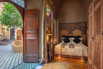 a bedroom with a bed and an open door at Riad KHOL Bohémia in Marrakech