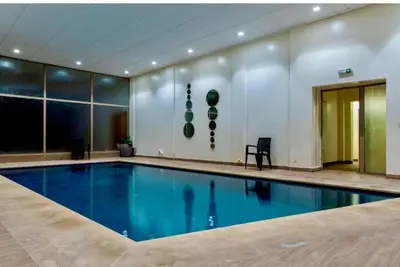 a large swimming pool in a large room with at Superbe appartement Hivernage in Marrakech
