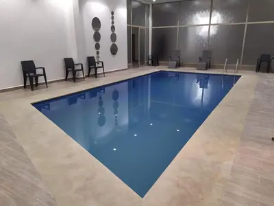 a large swimming pool with chairs around it at Superbe appartement Hivernage in Marrakech