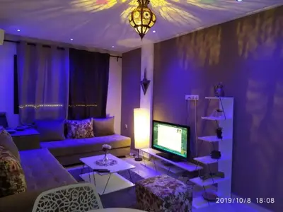 a living room with a couch and a television at Superbe appartement Hivernage in Marrakech