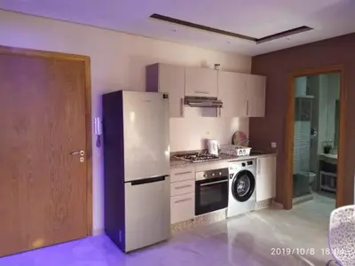 a kitchen with a white refrigerator and a stove at Superbe appartement Hivernage in Marrakech
