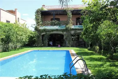a swimming pool in front of a house at Magnifique villa avec piscine chauffée que pour famille in Marrakech