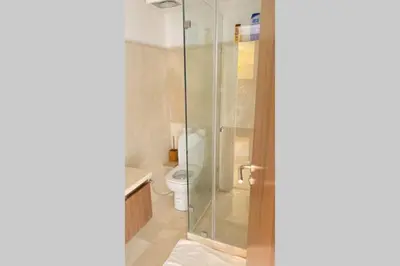 a bathroom with a toilet and a glass shower at Cosy Duplex, dans résidence avec piscine in Marrakech