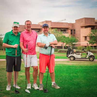 three men posing for a picture on a golf course at Prestigia Golf City Marrakech in Marrakech