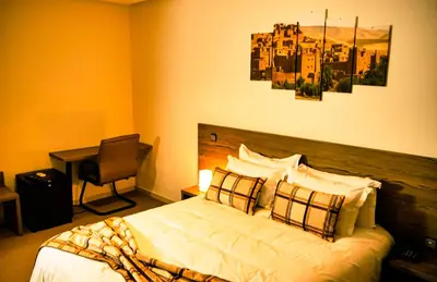 a bedroom with a bed and a desk with a chair at EL MOUSSAFIR HOTEL in Marrakech